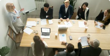 aged-senior-businesswoman-giving-presentation-multiracial-group-office-meeting - Formoz formation du cse en salle de réunion